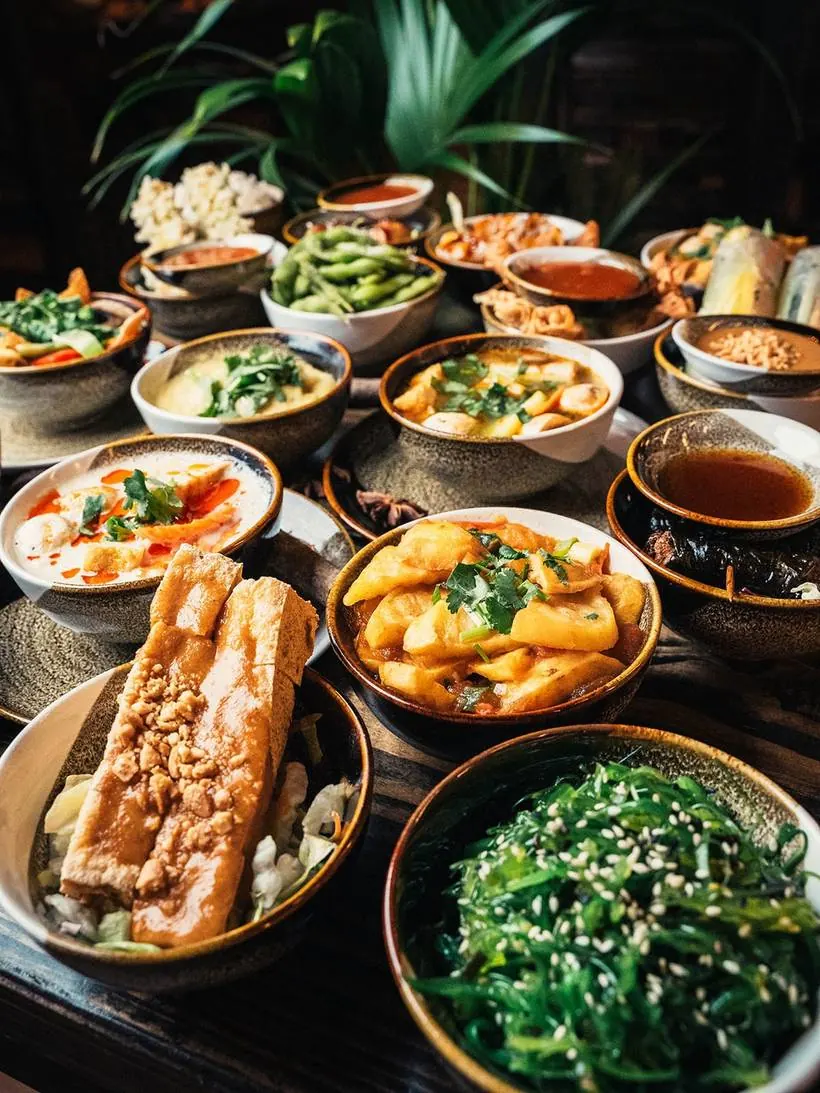 Tisch voller veganer Tapas, Bowls und Sushi im House of Vegan