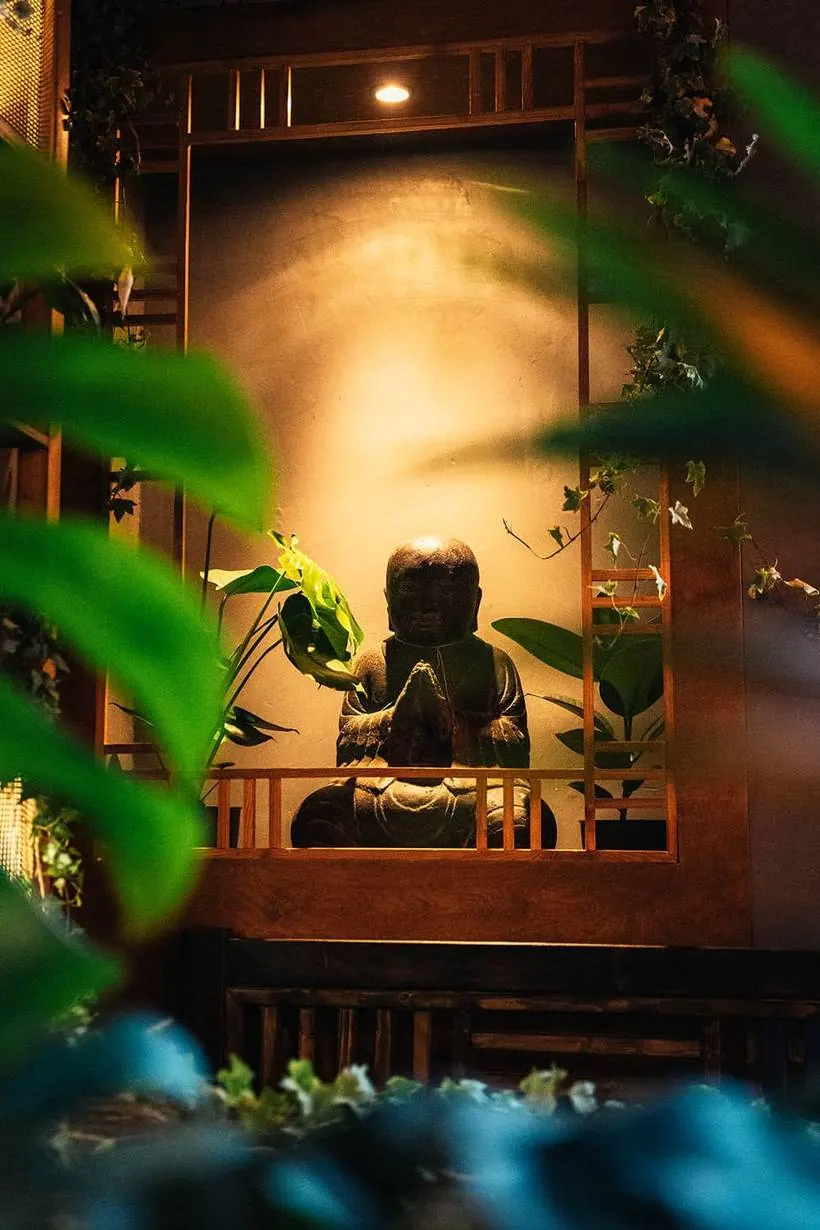 Beleuchtete Buddha-Figur im Holzrahmen im House of Vegan